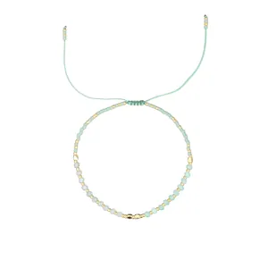 Handmade Morse code beaded bracelet with mint green stones and gold accents on a white background.