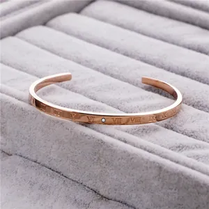 Nahaufnahme eines roségoldenen Armreifs mit römischen Ziffern und Diamant in der Mitte