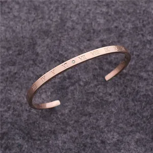 Detailansicht eines roségoldenen Armreifs mit römischen Ziffern und kleinem Diamantakzent