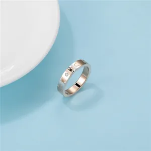 Vista dettagliata di un anello in acciaio bicolore con trama puzzle e diamante.