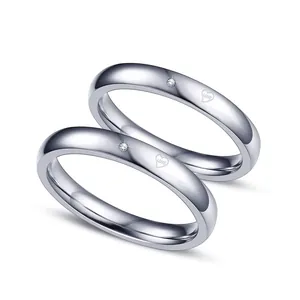 Detailansicht silberne Pärchenringe mit Herzgravur 'Love' und kleinem Diamanten