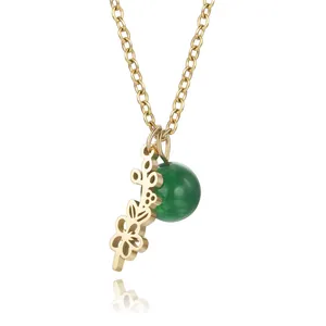 Detail view of titanium steel gold flower necklace with elegant green bead pendant