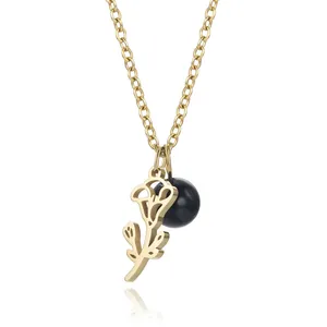 Detailed close-up of golden stainless steel necklace featuring hollow flower and blue bead