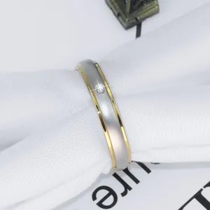 Detailaufnahme eines zweifarbigen Edelstahlrings mit einem einzelnen eingesetzten Diamanten