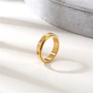 Primer plano de anillo giratorio dorado con piedras sobre fondo