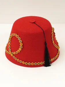 Detailed view of a red felt Fez hat with multi-colored gemstones and black tassel