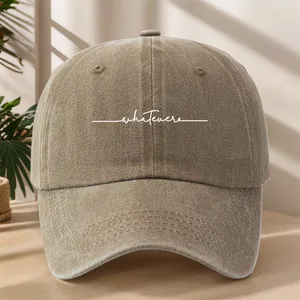 Dettaglio ravvicinato di un cappellino da baseball vintage lavato kaki con scritta 'whatever'
