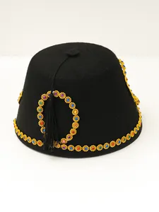 Detailed view of luxury black felt fez hat with colorful gemstone gold trim and black tassel