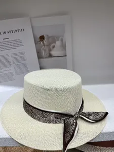 Detailed view of a vintage hollow-out straw boater hat with a paisley ribbon bow