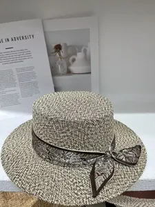 Macro detail of a vintage woven straw boater hat featuring an elegant paisley ribbon