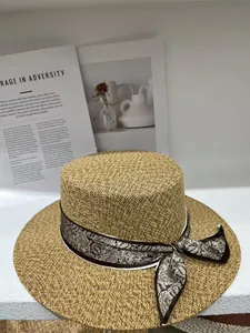 Detailed view of a vintage flat top straw hat with an elegant paisley ribbon bow