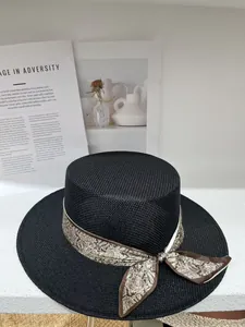 Detailed view of a black hollow-out straw boater hat with a paisley ribbon bow.