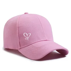 Rosa Baseballkappe mit einem weiß gestickten Herzdesign auf einem schlichten weißen Grund.