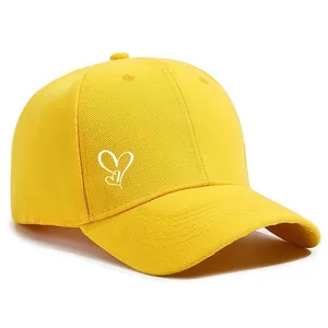 Detailansicht einer leuchtend gelben Baseballkappe mit eleganter weißer Herzbestickung.