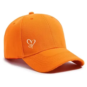 Detailansicht der weißen Herzstickerei auf einer leuchtend orangefarbenen Baseballkappe