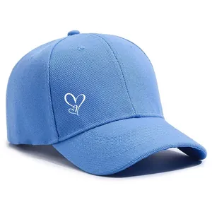 Nahaufnahme einer himmelblauen Baseballkappe mit weißer Herzstickerei auf der Seite.