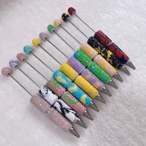 Close-up detail of colorful rhinestone-encrusted ballpoint pens in various patterns.
