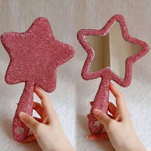 Detailaufnahme des glitzernden rosa Strassrandes am sternförmigen Handspiegel.