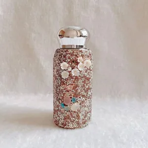 Detailansicht der Luxus-Strass-Thermoskanne mit 3D-Blumendesign und Perlenverzierung
