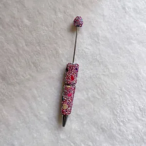 Close-up detail of handmade pink rhinestone beadable pen decorated with colorful gems