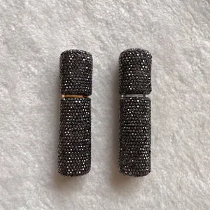 Close-up of two 10ml rhinestone-encrusted portable perfume spray bottles for travel