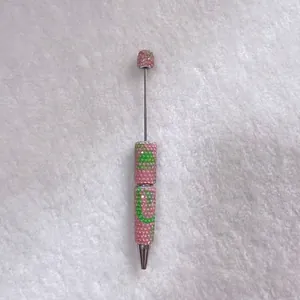 Close-up of candy-colored rhinestone ballpoint pen with pink and green crystals