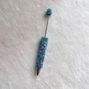 Detailed view of handmade blue rhinestone beadable pen with heart charms