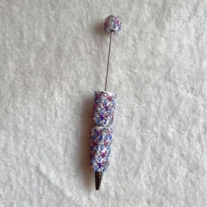 Detail view of an ornate beadable pen decorated with purple butterflies and pearls.