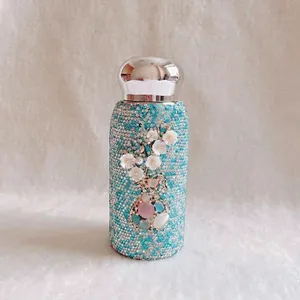 Detailansicht der blauen diamantbesetzten Thermoskanne mit elegantem Blumenmotiv