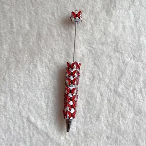 Detailed view of heavy craft beaded ballpoint pen with red butterfly and pearls