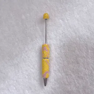 Detailed view of candy color handmade rhinestone encrusted ballpoint pen on white background
