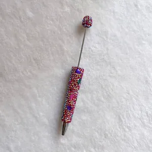 Close-up of handmade colorful rhinestone pen with sparkling crystals on white background
