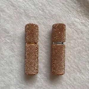 Detail view of two 10ml refillable perfume atomizers covered in champagne rhinestones