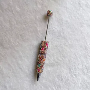 Detail view of colorful handmade rhinestone pen with heart stones and sparkling beads.