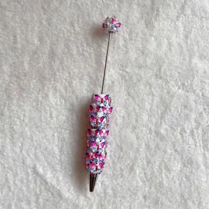 Close-up of cute beadable ballpoint pen with pink butterfly and pearl beads