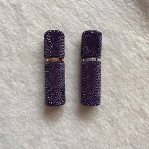 Close-up of portable 10ml perfume atomizers fully embellished with purple crystals