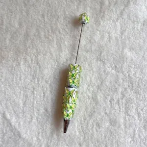 Detail of butterfly beaded ballpoint pen with green charms and white pearls