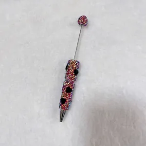 Macro detail of handmade colorful rhinestone beadable pen with black heart-shaped jewels.