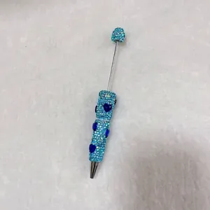 Detailed view of handmade blue rhinestone pen with dark blue heart-shaped crystal charms
