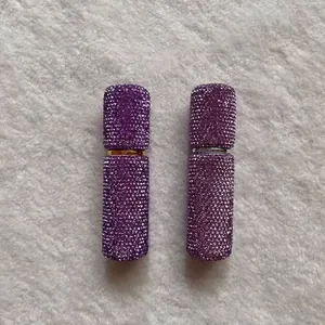 Close-up of luxury 10ml purple rhinestone-encrusted portable perfume spray bottles
