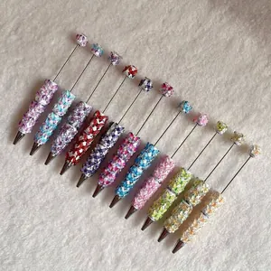 Colorful DIY beaded ballpoint pens featuring butterfly beads and sparkling diamond accents