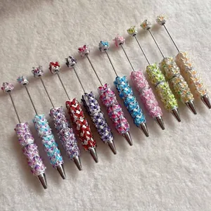 Detailed collection of decorative beaded ballpoint pens with colorful butterfly charms