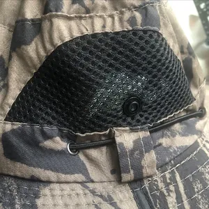 Detail of camouflage fan hat showing breathable black mesh and integrated cooling fan