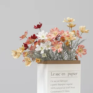 Macro detail of multi-colored silk cosmos flowers in a minimalist decorative paper bag