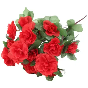 Close-up detail of vibrant red artificial azalea silk flowers with green leaves