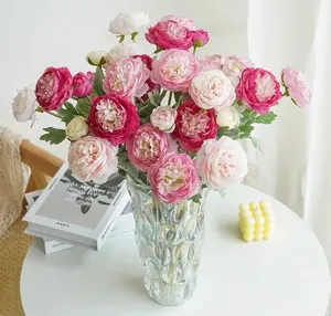 Elegant artificial pink ranunculus bouquet in glass vase for stylish home table decoration