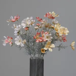 Macro detail of lifelike artificial cosmos flowers in warm pink and yellow tones for home decor