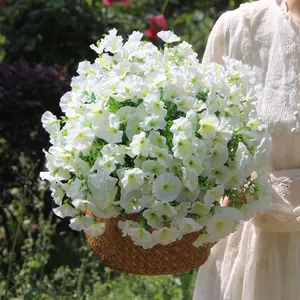 Artificial white morning glory bouquet held in a rustic woven basket for garden decor