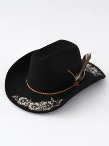 Detail eines schwarzen Cowboyhuts aus Filz mit Blumenstickerei und Federschmuck