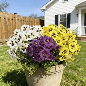 Close-up of vibrant purple, yellow, and white artificial pansies in a stone pot